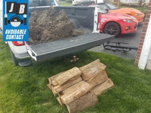 Silverado LTZ truck bed load of dirt and logs