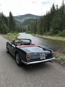maserati spyder vignale rear three-quarter beside mountain stream