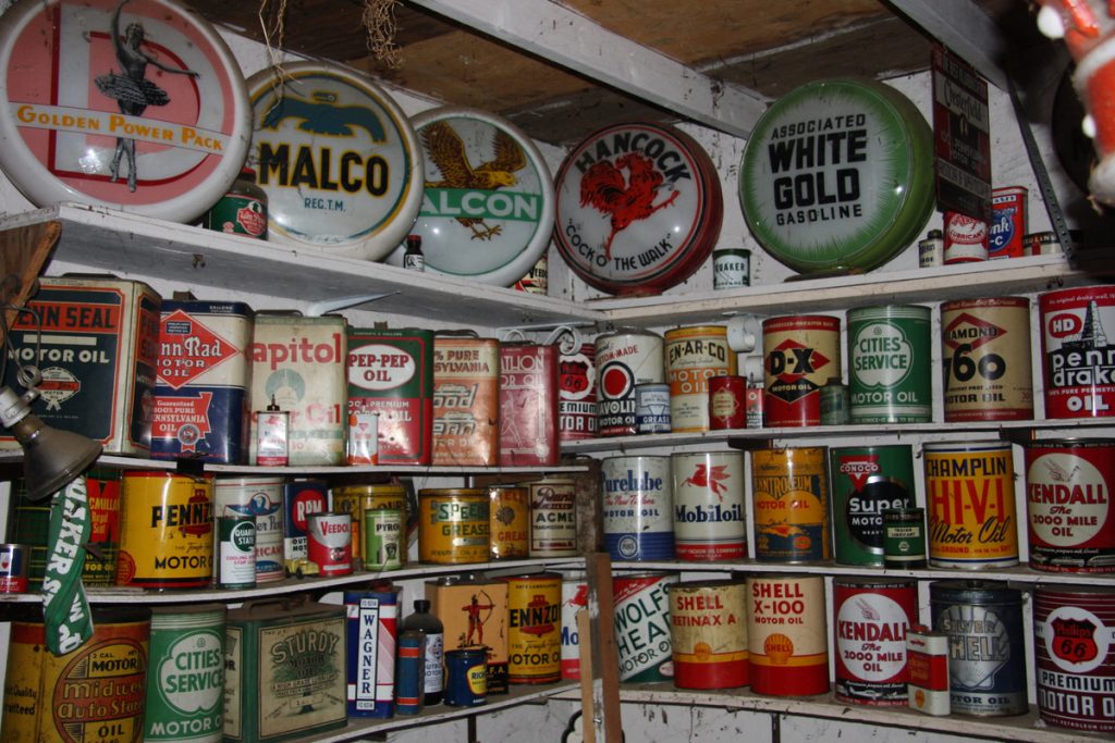 vintage oil cans and signs on shelves
