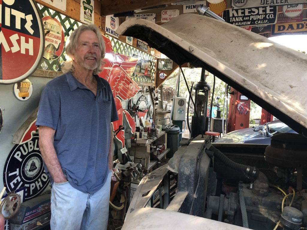 tom donahue stands in garage beside open car hood