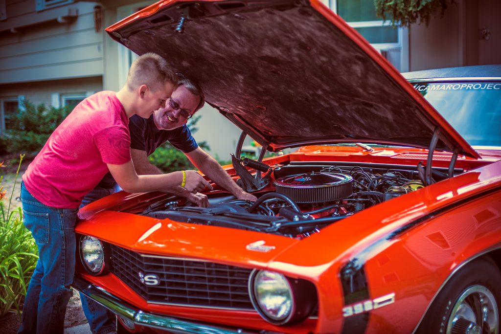 Father and Son Under Camaro Engine Bay