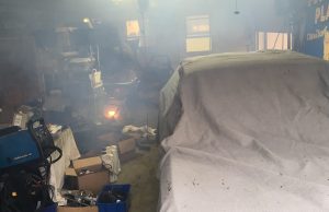 Rob Siegel - Sorting out a car - Dimly lit garage with junk