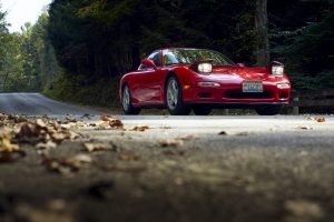 Mazda RX-7 front three-quarter dynamic road action lights up