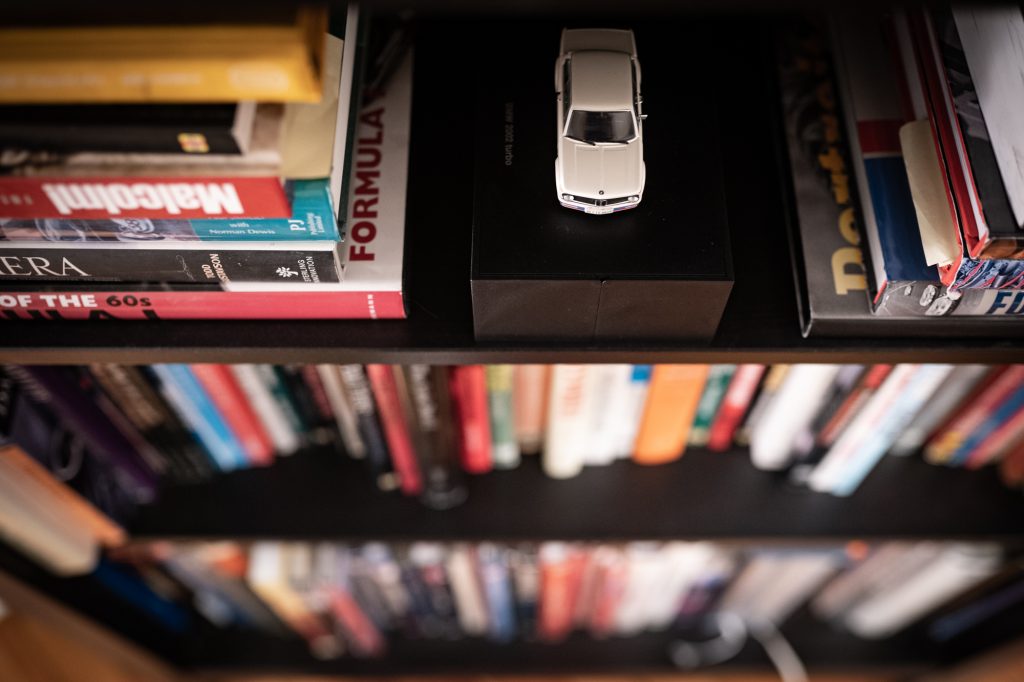 white bmw 2002 miniature on bookcase shelf