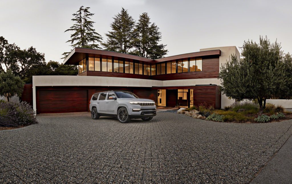 Grand Wagoneer Concept hero front three quarter in front of techno house