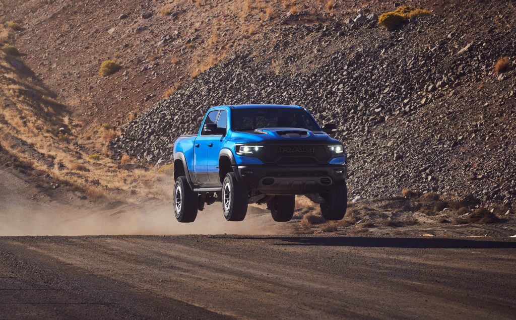 2021 Ram 1500 TRX front three-quarter dirt track dynamic action airborne blue