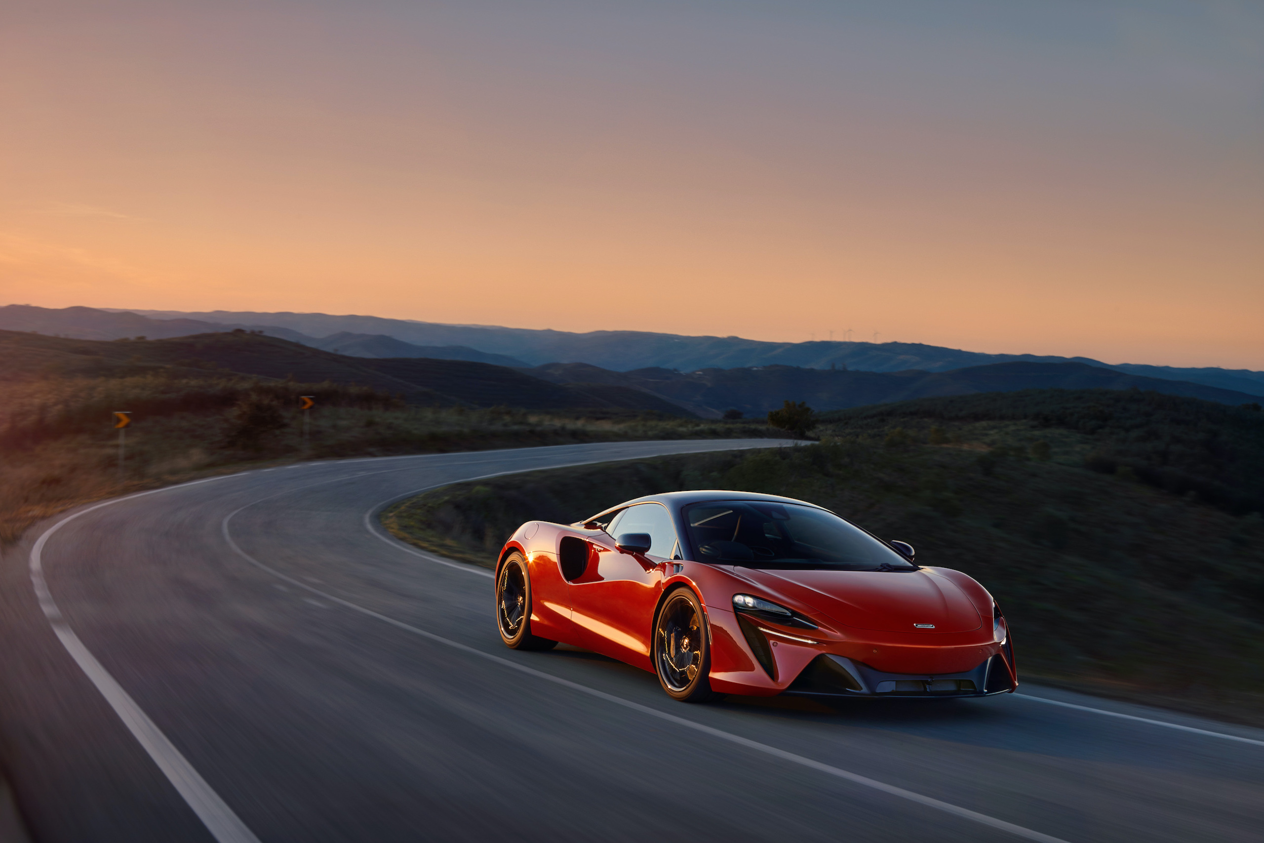 McLaren Artura orange front three-quarter sunset action