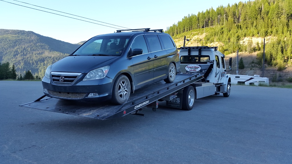 honda odyssey loaded on flatbed tow truck