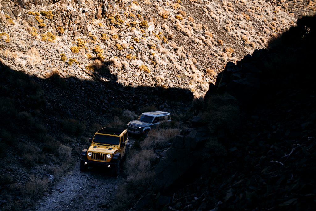 land rover defender following jeep wrangler rubicon up mountain two track