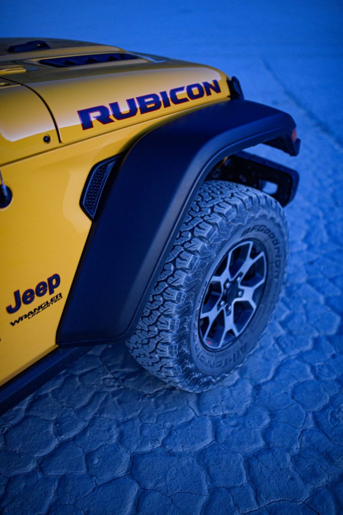 jeep wrangler rubicon front wheel and tire on blue desert floor