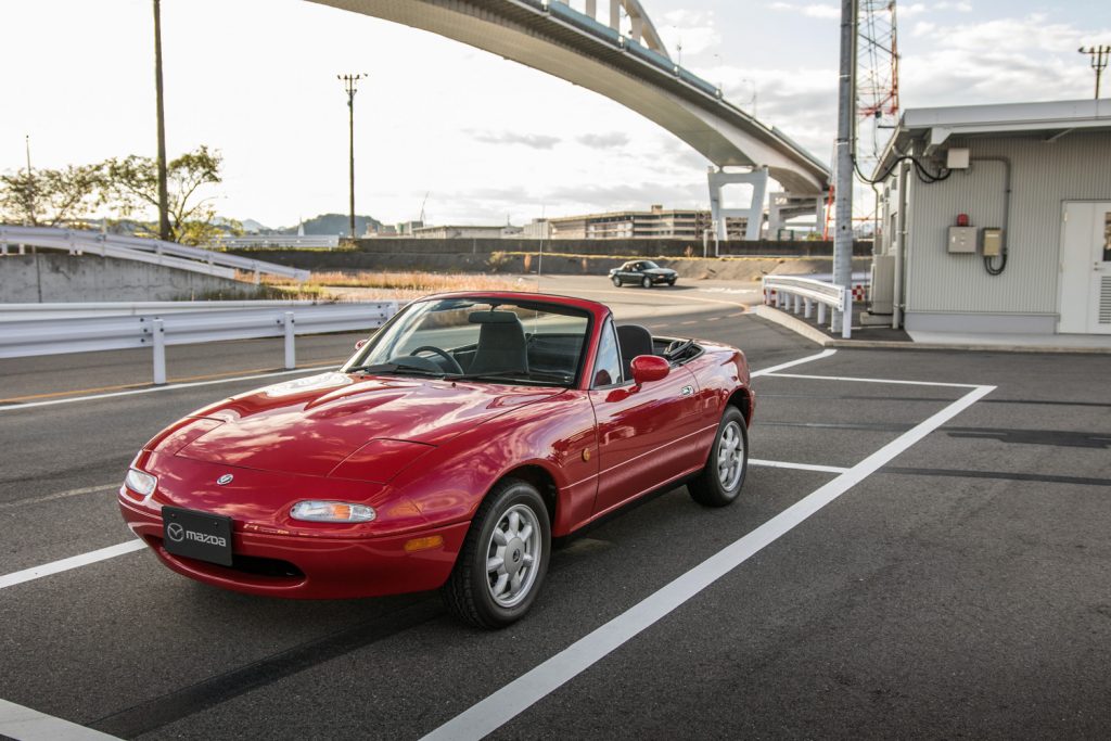 red na miata front three-quarter parked highway overpass
