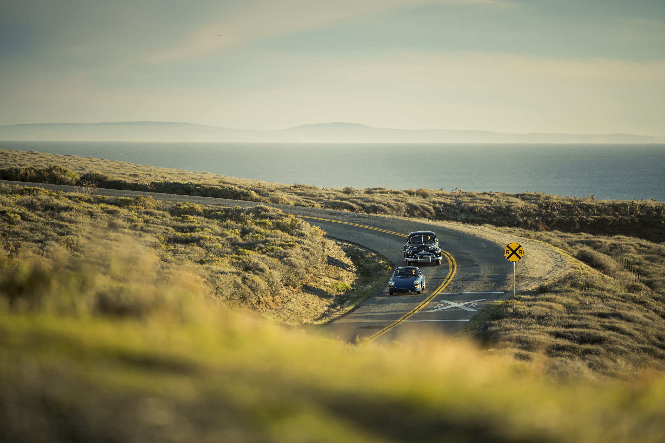 1946 Buick Special and 1970 Porsche 911 drive ocean view