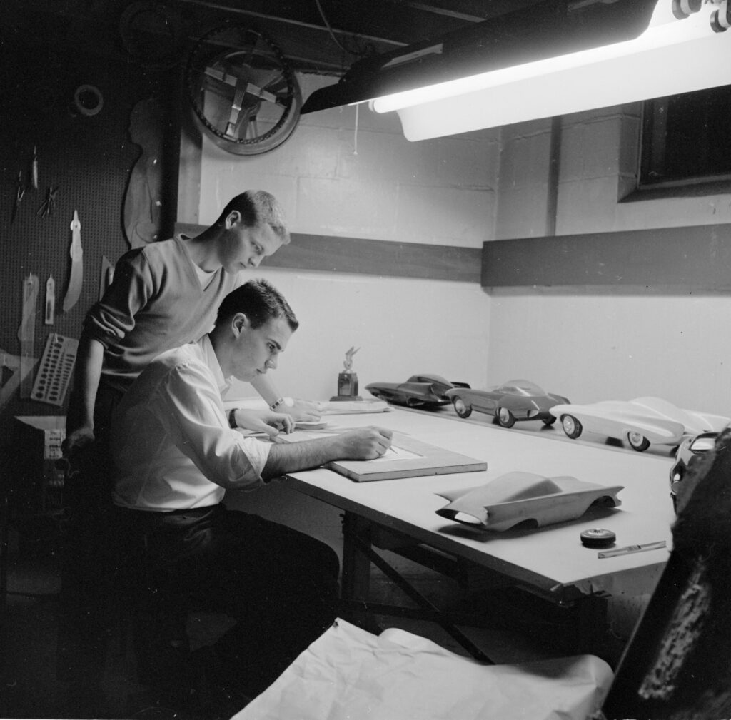 Two young aspiring car designers drafting a design